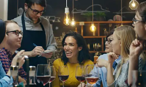 a couple of people are drinking from a wine glass