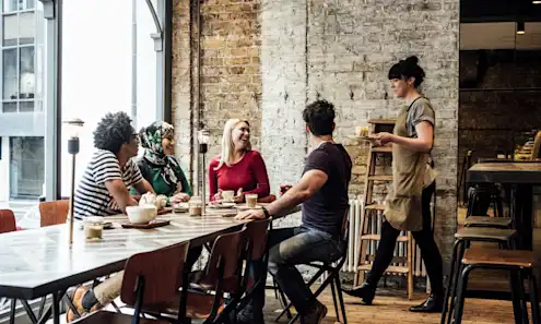 a group of people sitting at a table in a restaurant