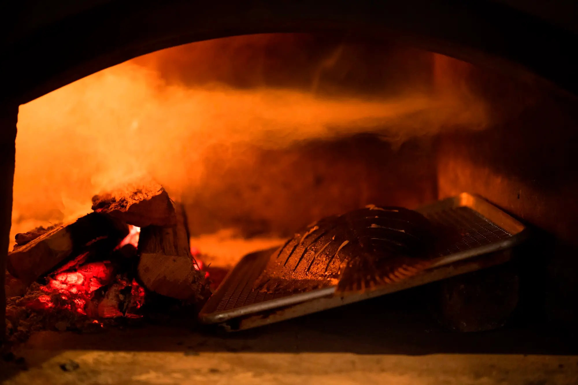 a pizza sitting on top of a fire oven