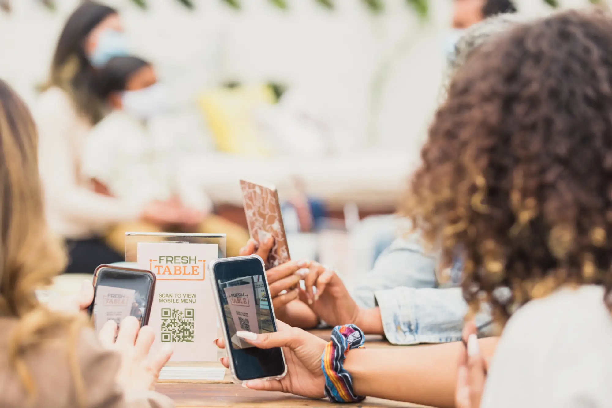 A group of diners using qr codes to view menus