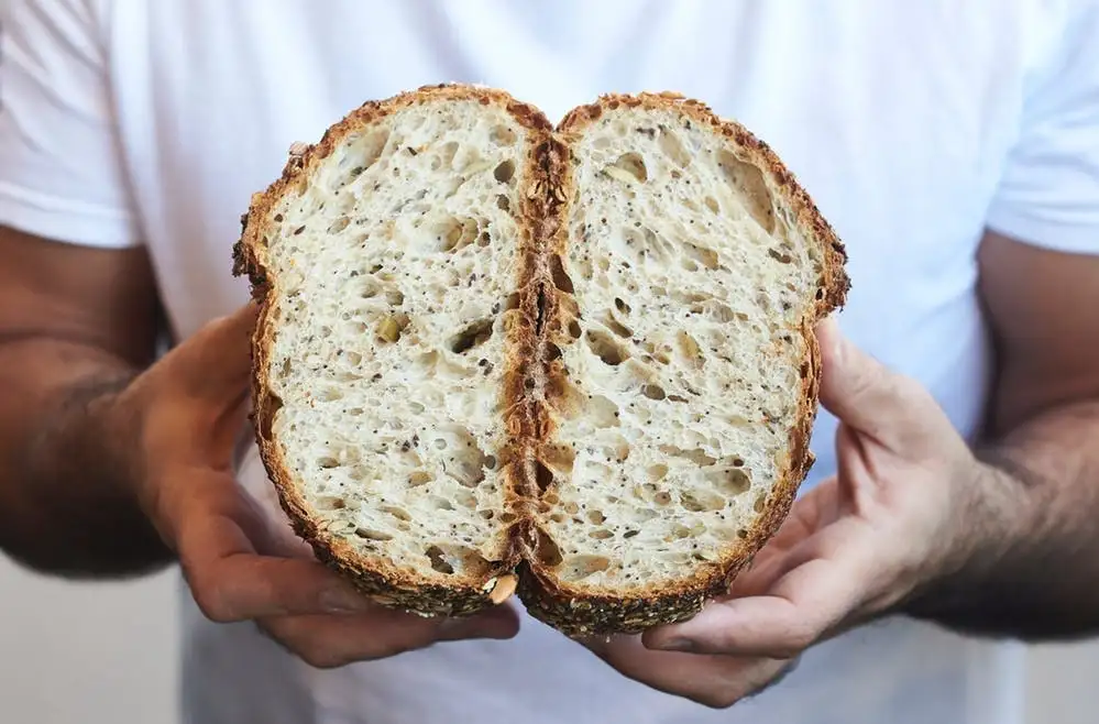 a hand holding a piece of bread