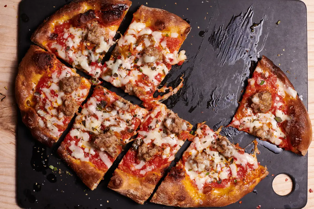 a slice of pizza sitting on top of a cutting board