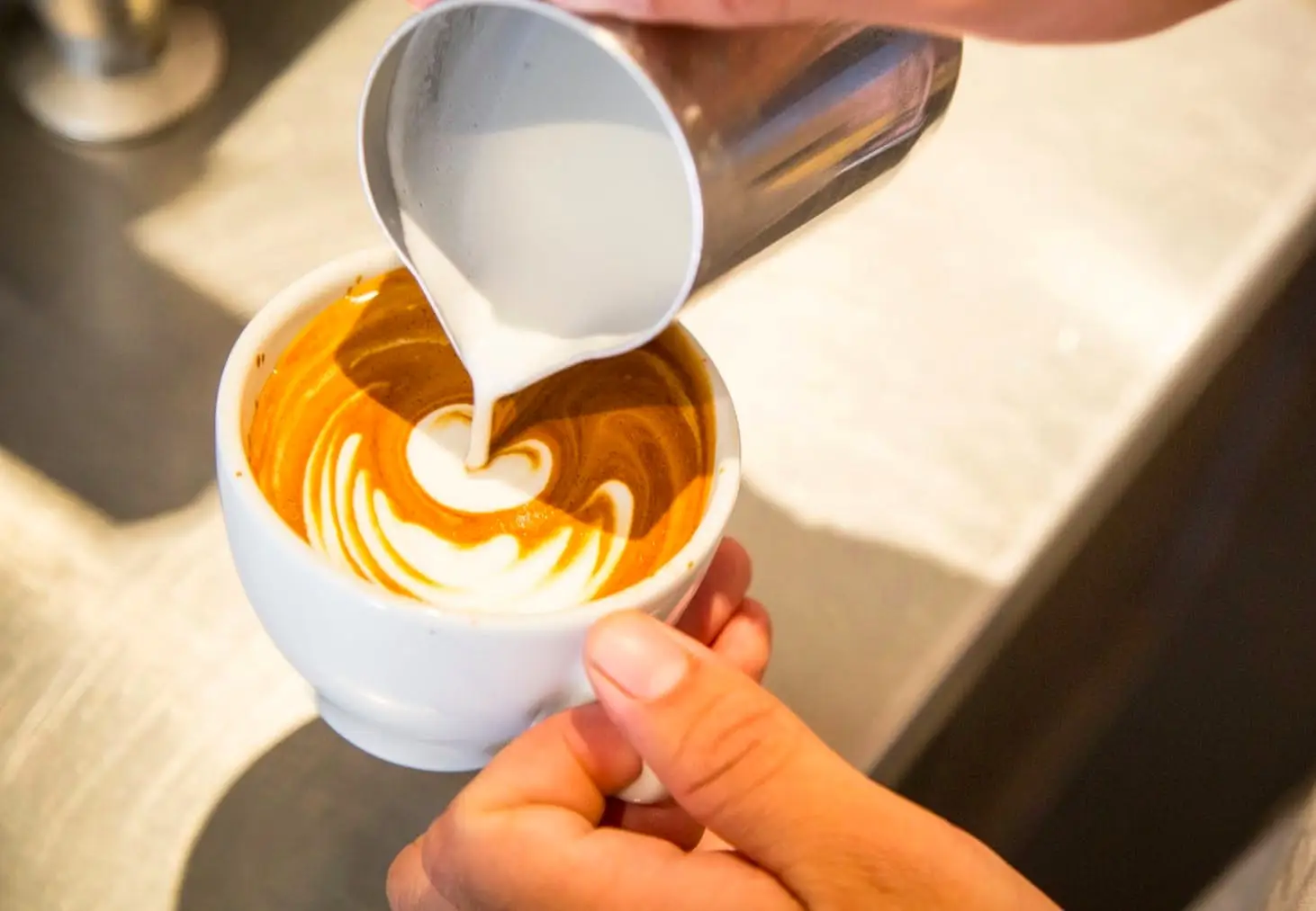 a hand holding a cup of coffee