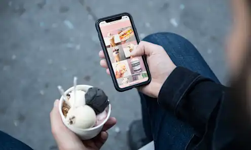 a hand holding a cell phone eating Milk Sugar Love ice cream