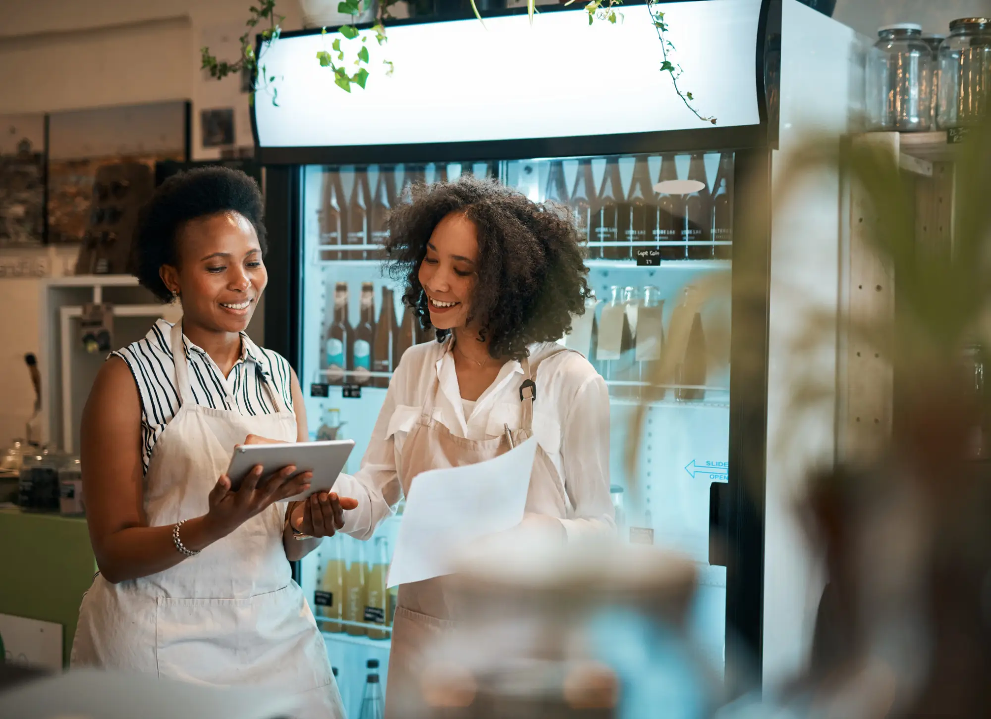Two women looking at a tablet computer in a restaurant