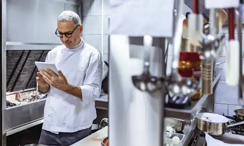 a man standing in a kitchen preparing food