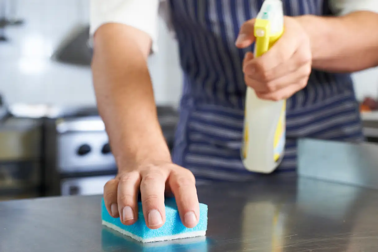 A person cleaning a commercial kitchen