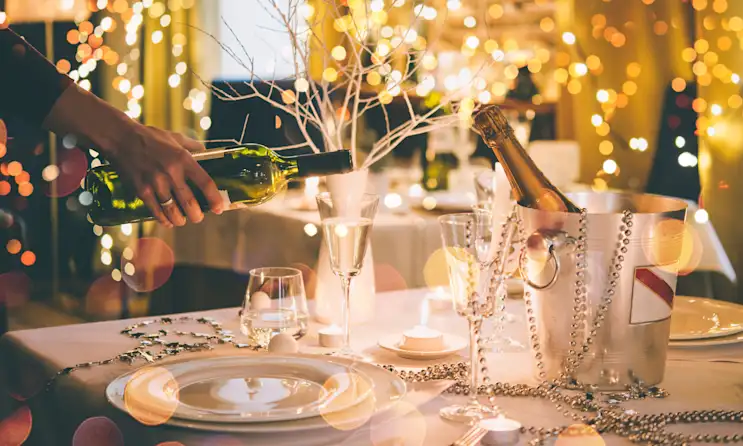 Restaurant staff pouring wine at a table
