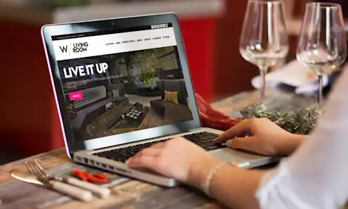 a person sitting at a table using a laptop computer