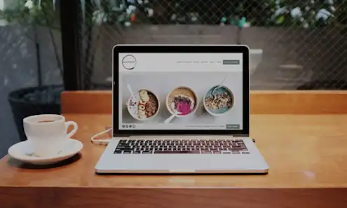 a laptop computer sitting on top of a wooden table