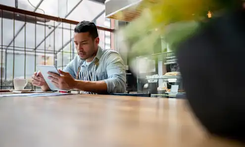 a person sitting at a table using a laptop