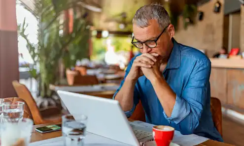 a man sitting at a table using a laptop