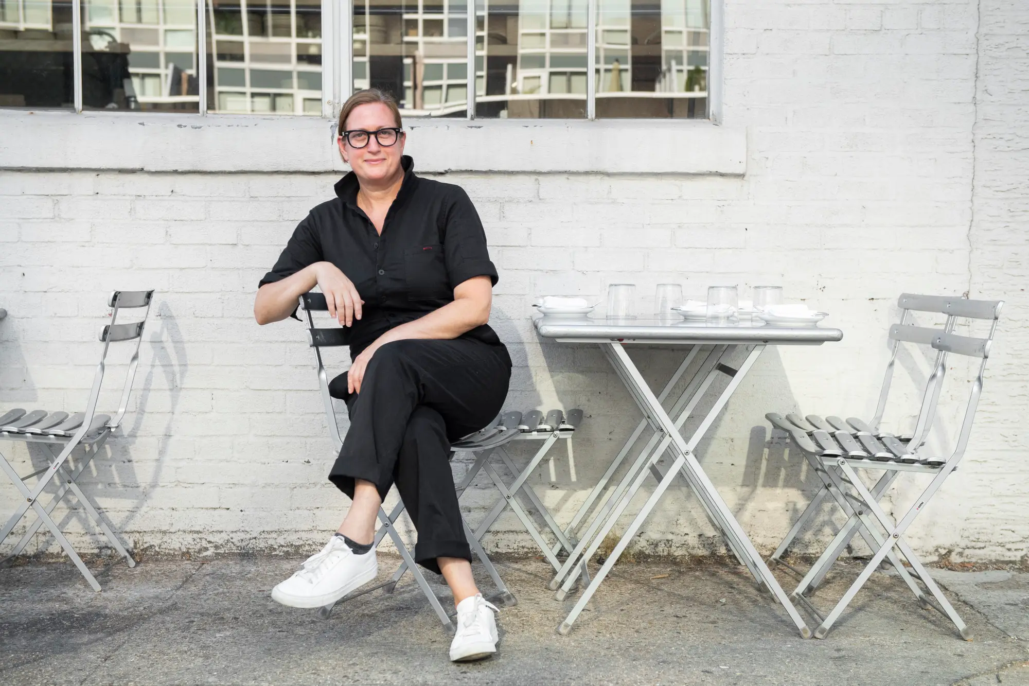 a woman sitting on a bench in front of a building