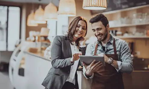 Restaurant owners reading a review of their restaurant on a tablet