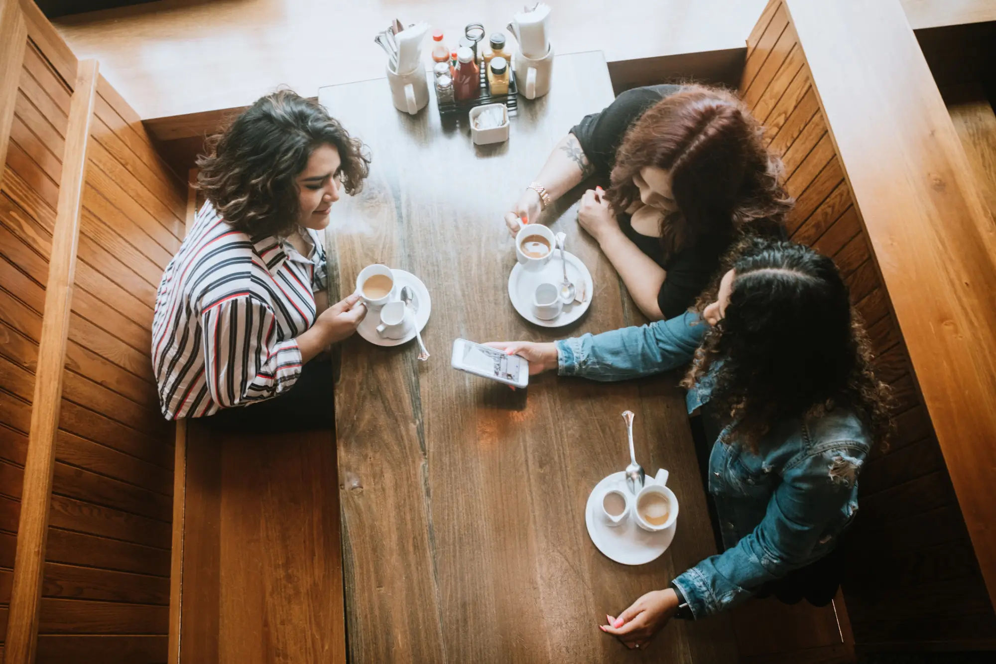 a group of people standing on top of a wooden table