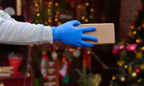 A person handing over a package during the holidays