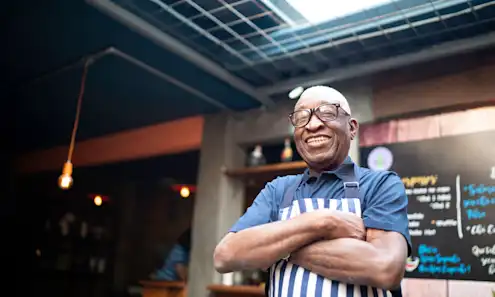 a restaurant owner standing in a restaurant.