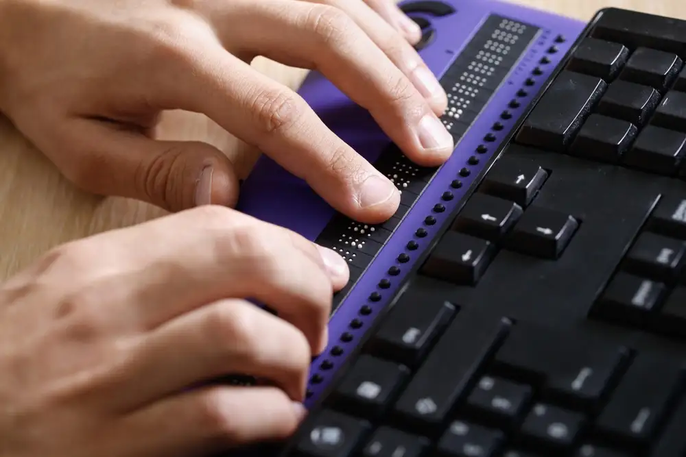 A user using a refreshable braille display.