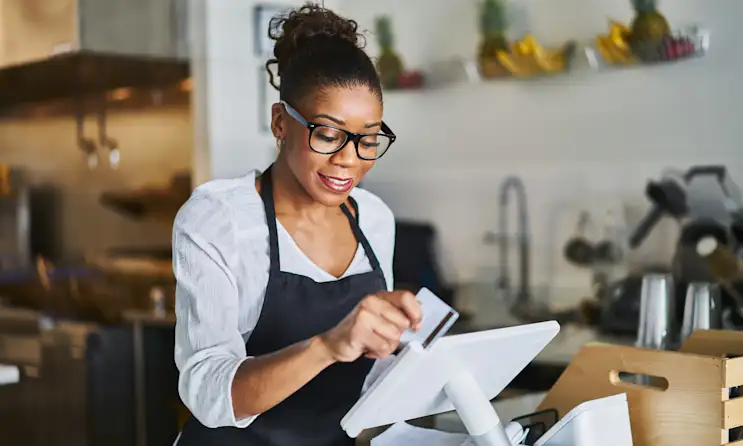 Woman swipes a credit card using a point of sale system