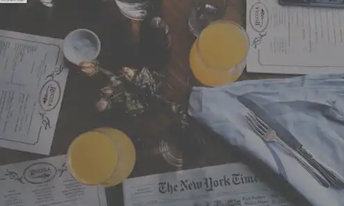 Restaurant menus, drinks and a newspaper on a table. 