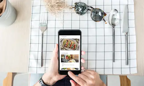 Person sitting at a table with a mobile device