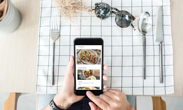 Person sitting at a table with a mobile device