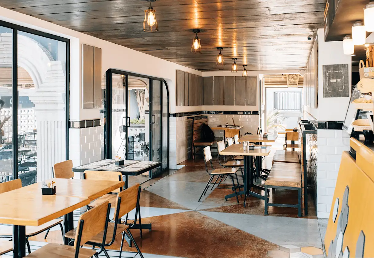 The interior of a restaurant with tables and chairs.