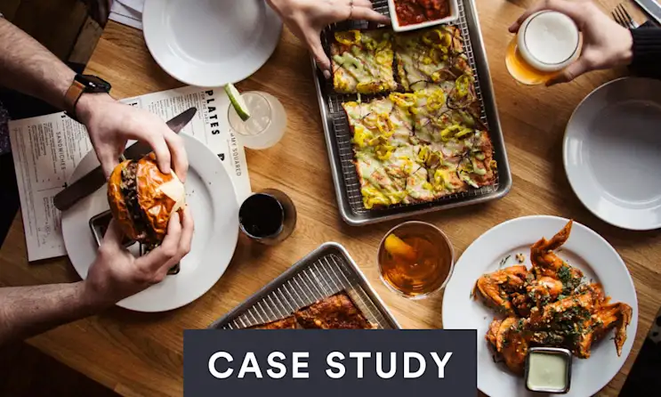 a group of people sitting at a table with a plate of food